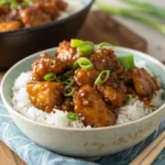 Crispy honey chicken in sticky glaze over rice